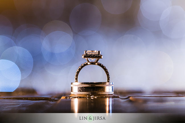 Bride's diamond engagement ring standing upright on groom's wedding band using putty technique