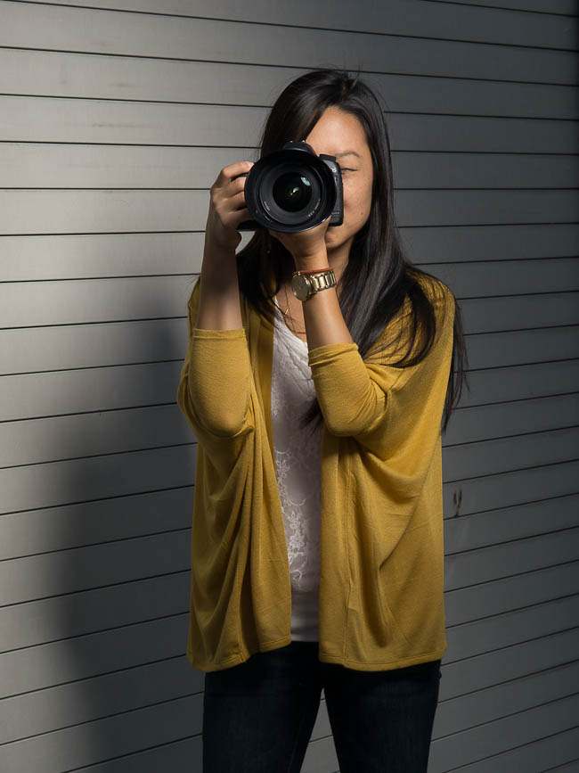 Correct camera holding technique with elbows tucked in against the torso and left hand supporting the lens from underneath