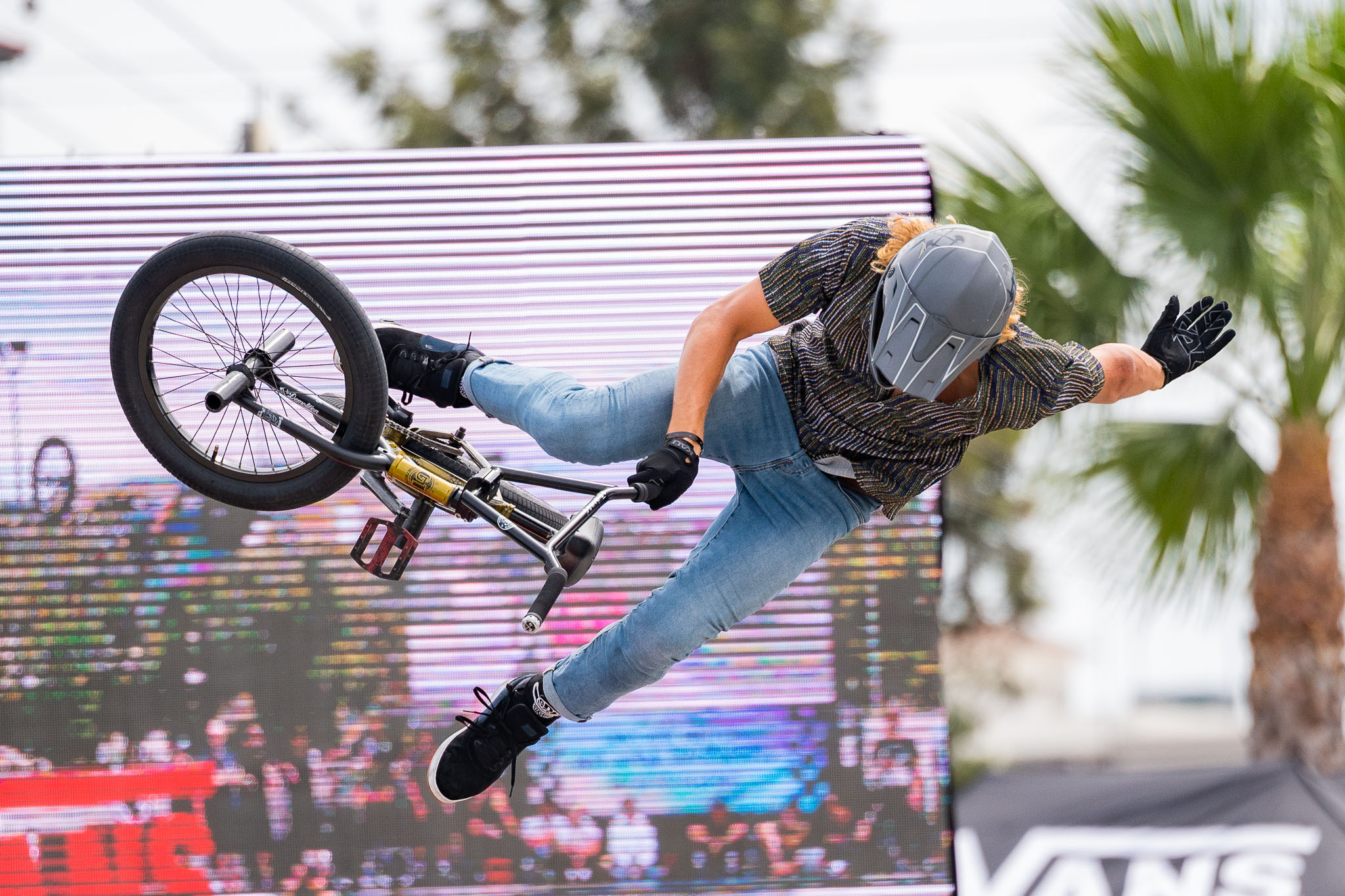 Sports photographer using a telephoto lens and fast shutter speed to capture action at an outdoor sporting event